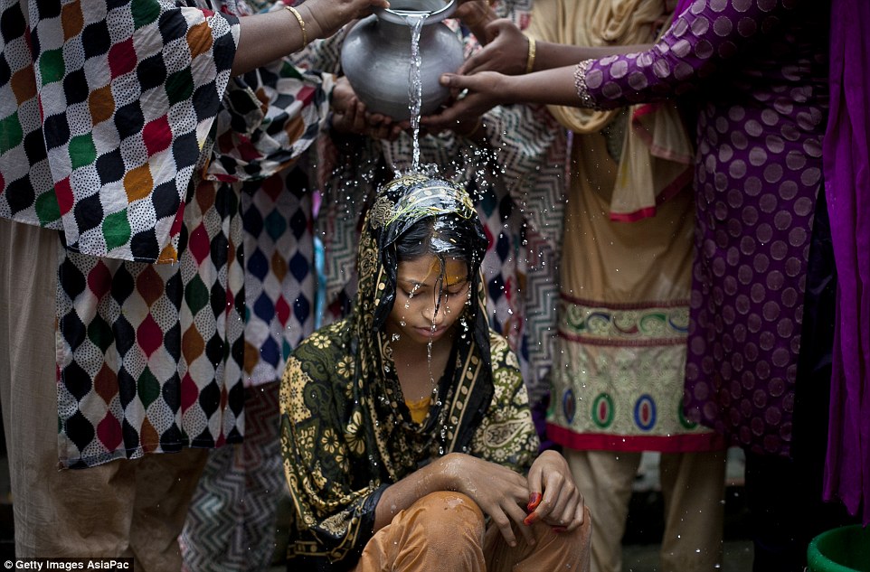 Sad: Nasoin Akhter is washed by relatives before her wedding to a 32-year-old man at the age of just 15