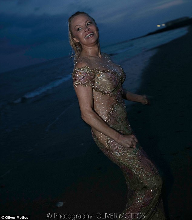 Oceanside stunner: The ageless beauty was seen splashing around in the tide wearing the glittery gold gown she donned for the red carpet walk