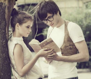 Парень и девушка читают книги возле дерева