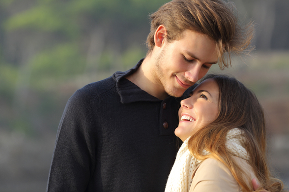 Happy couple hugging in love outdoors at sunset - how to show your love to a scorpio man