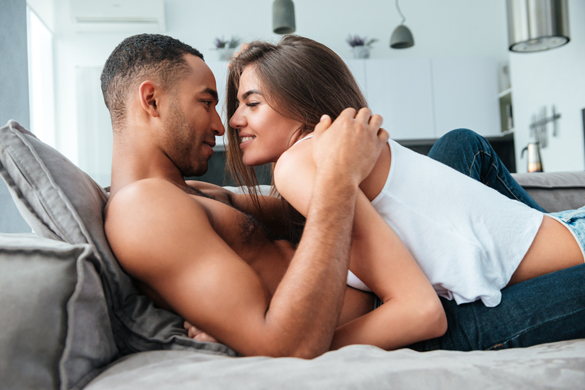 Tender young couple lying and hugging on couch at home - how to show your love to a scorpio man